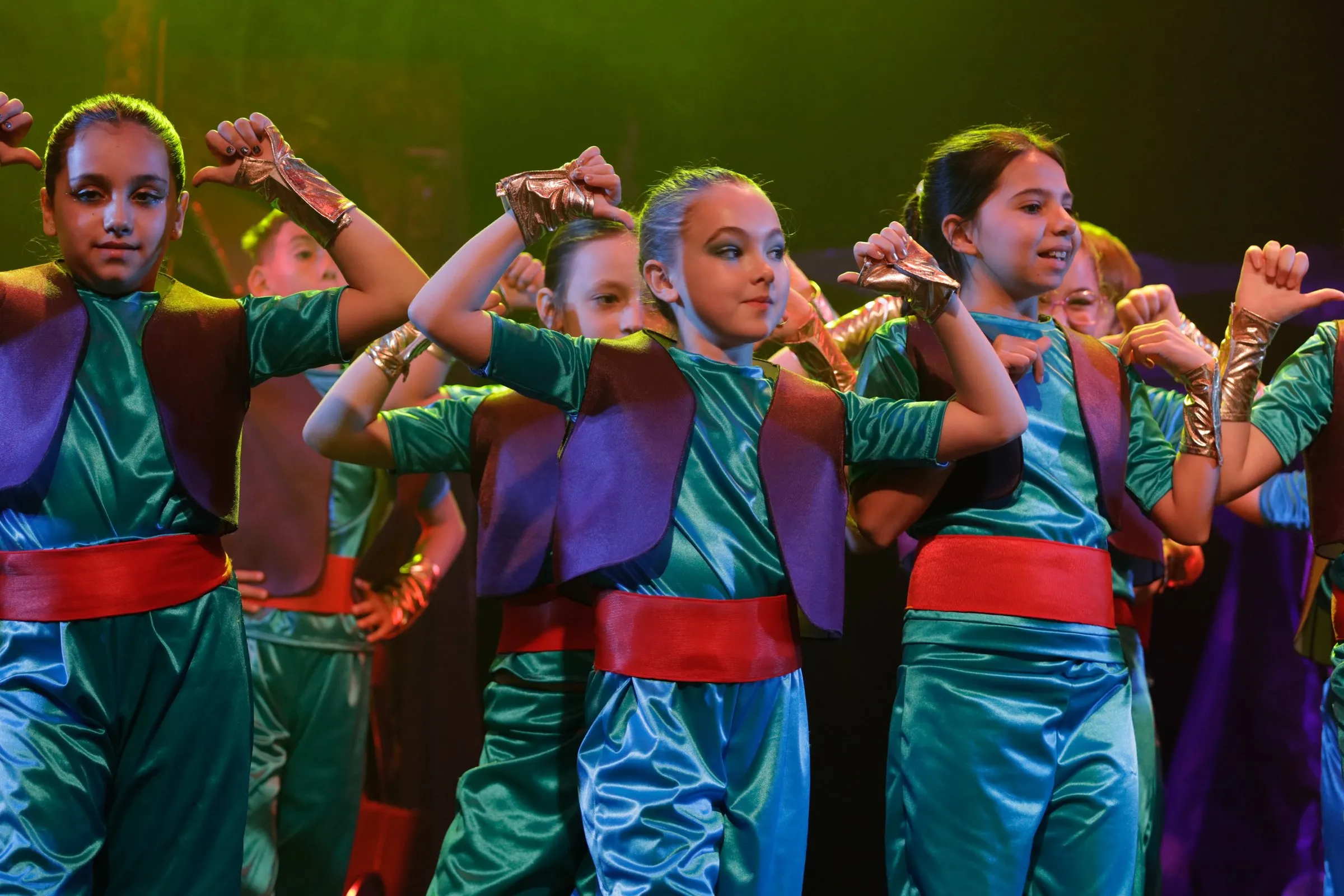 Bailarines de Arabian Nights en escena, con vestuario de colores