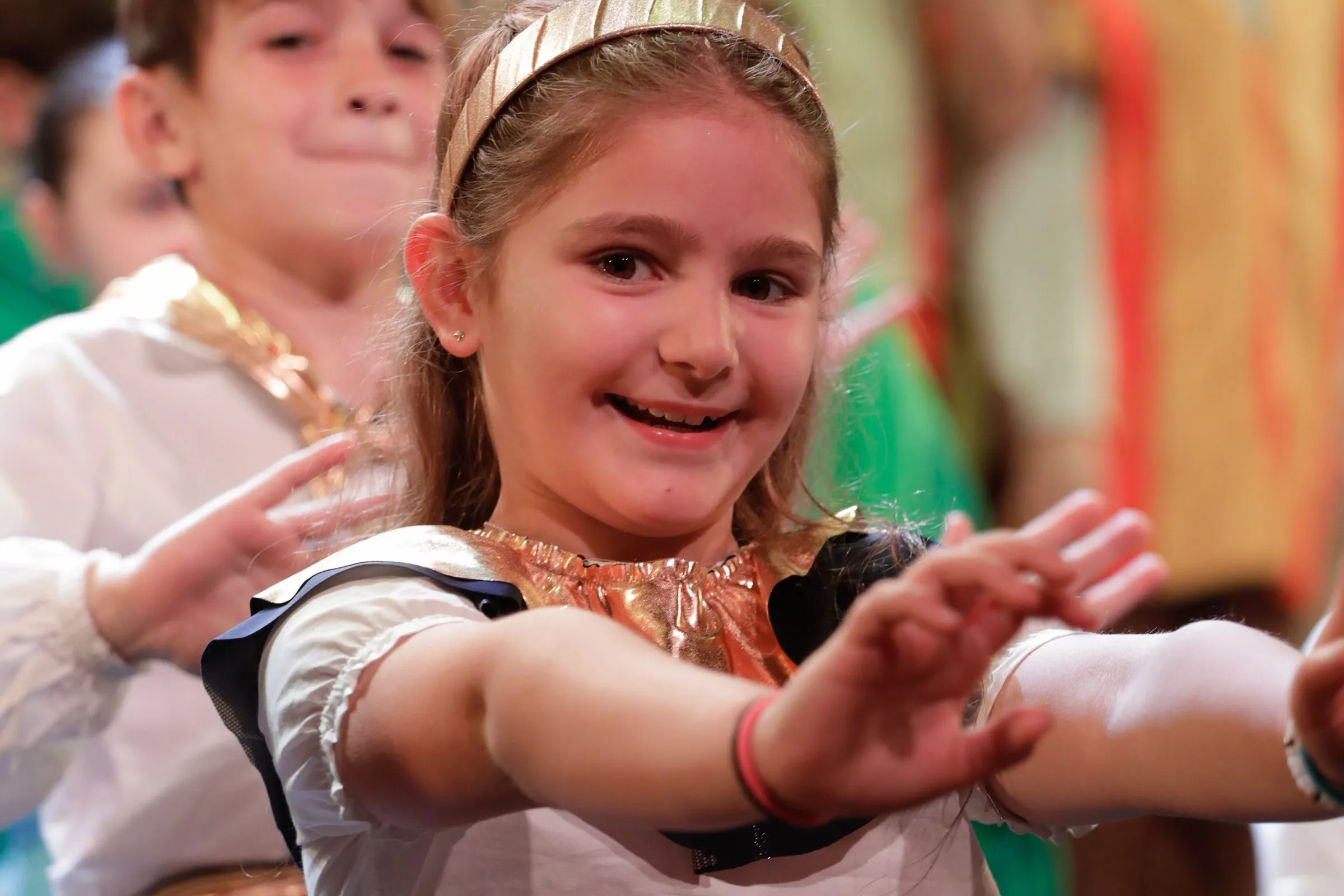 Una nena de Primaria canta en el concierto de fin de agosto, con vestuario de colores