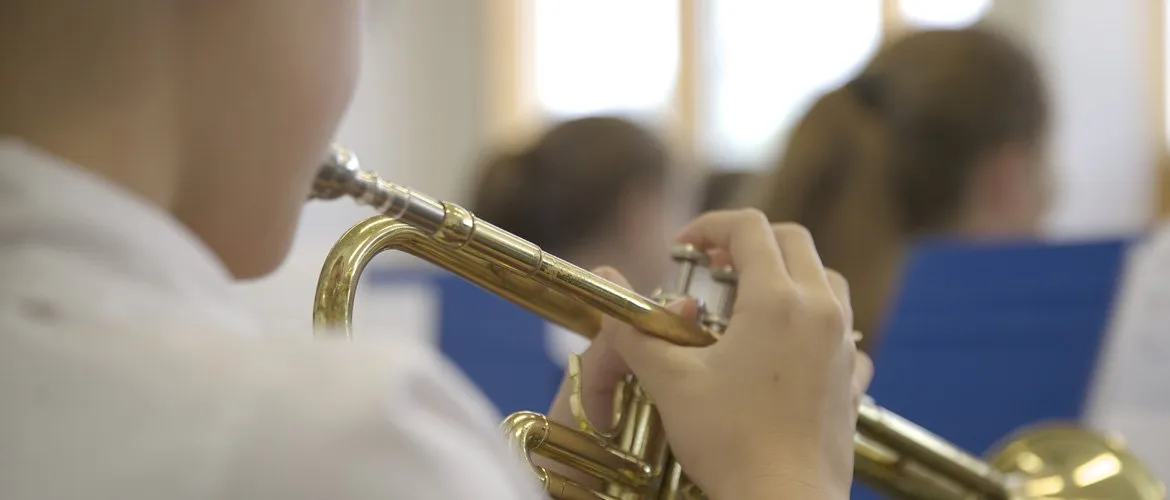 Un alumno toca la trompeta en la banda del colegio