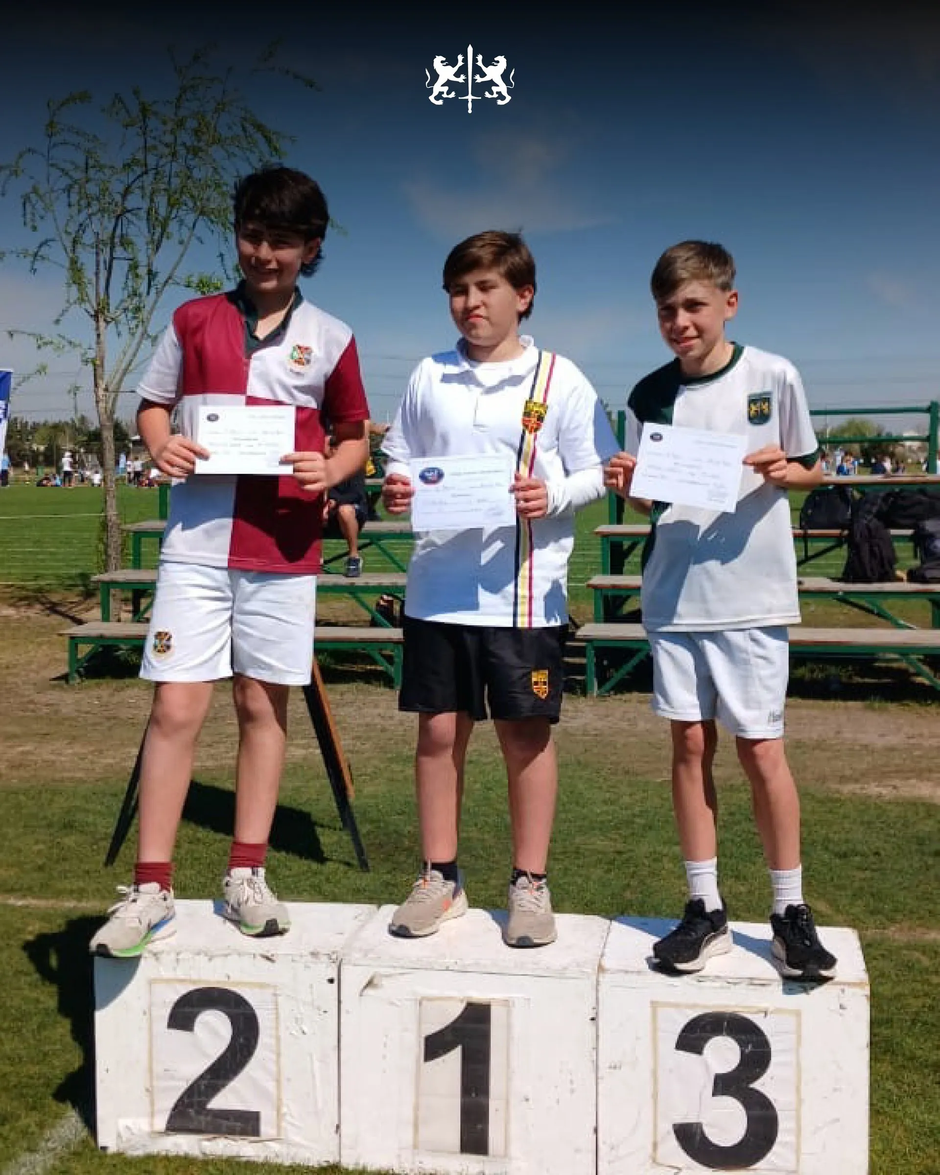 Tres alumnos en el podio de atletismo con sus certificados