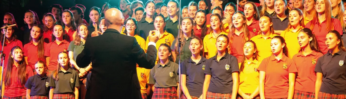 Los coros de los Houses, con las remeras de colores, cantan en el escenario