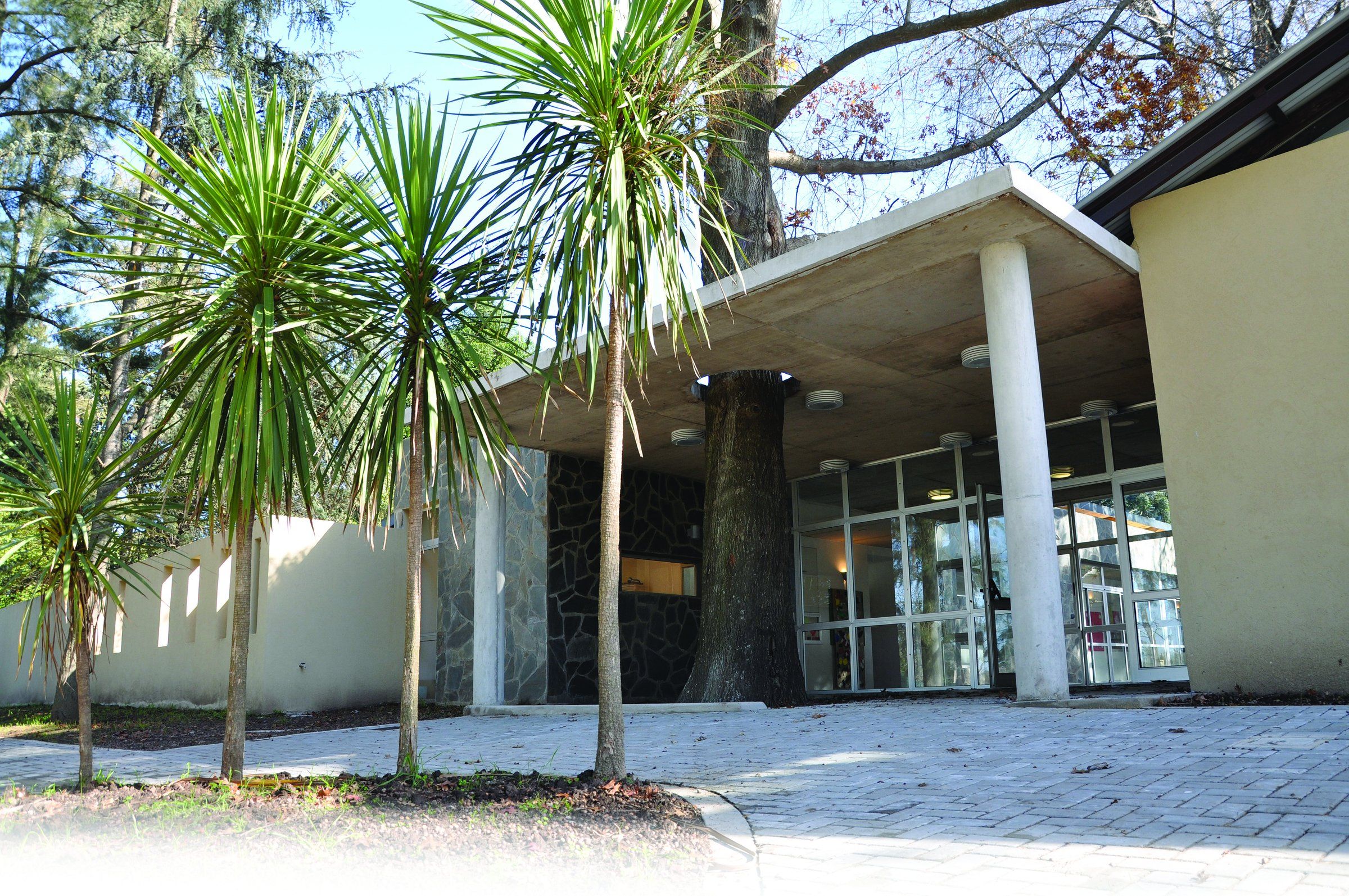 Edificio de la sede Nordelta, de líneas modernas, rodeado de palmeras y parque