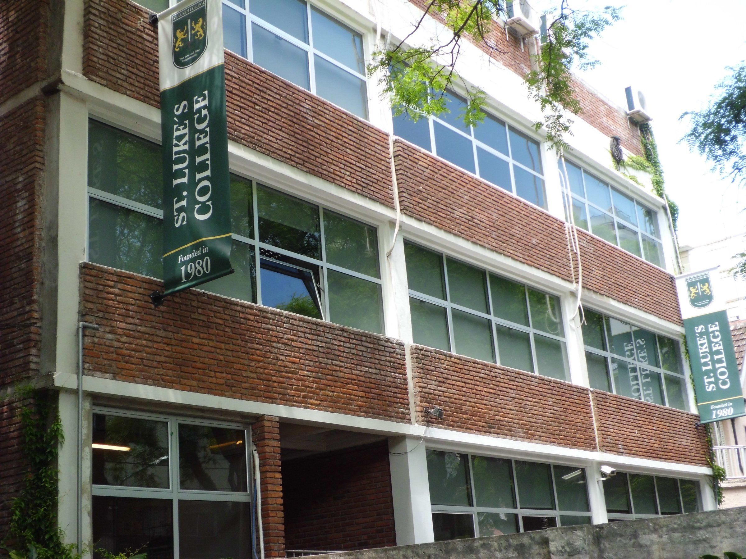 Fachada de ladrillo del edificio de St. Luke’s College en Olivos, con el nombre del colegio en el frente