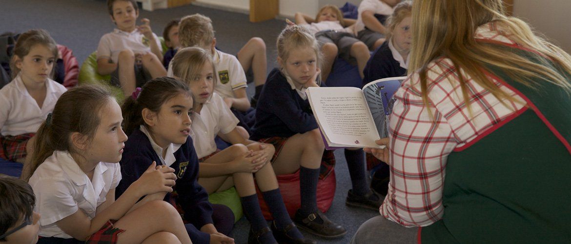 Chicos de Primaria escuchan un cuento sentados en ronda