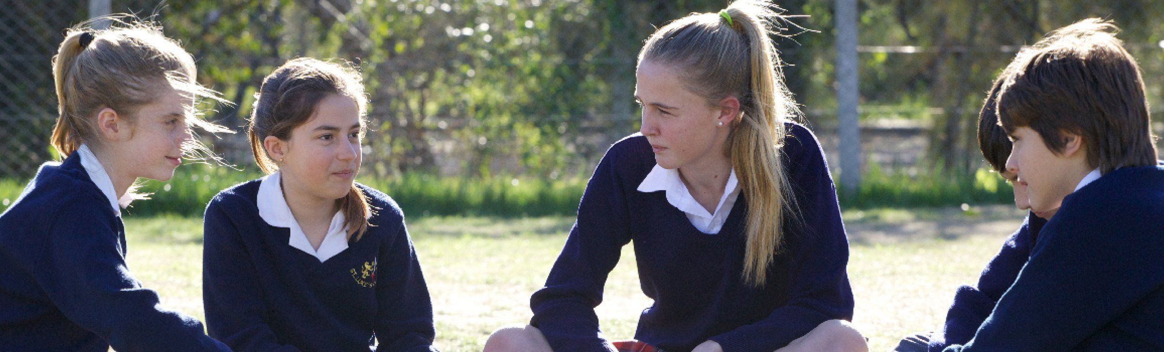 Una alumna de Secundaria en el campo de deportes, con los compañeros de fondo