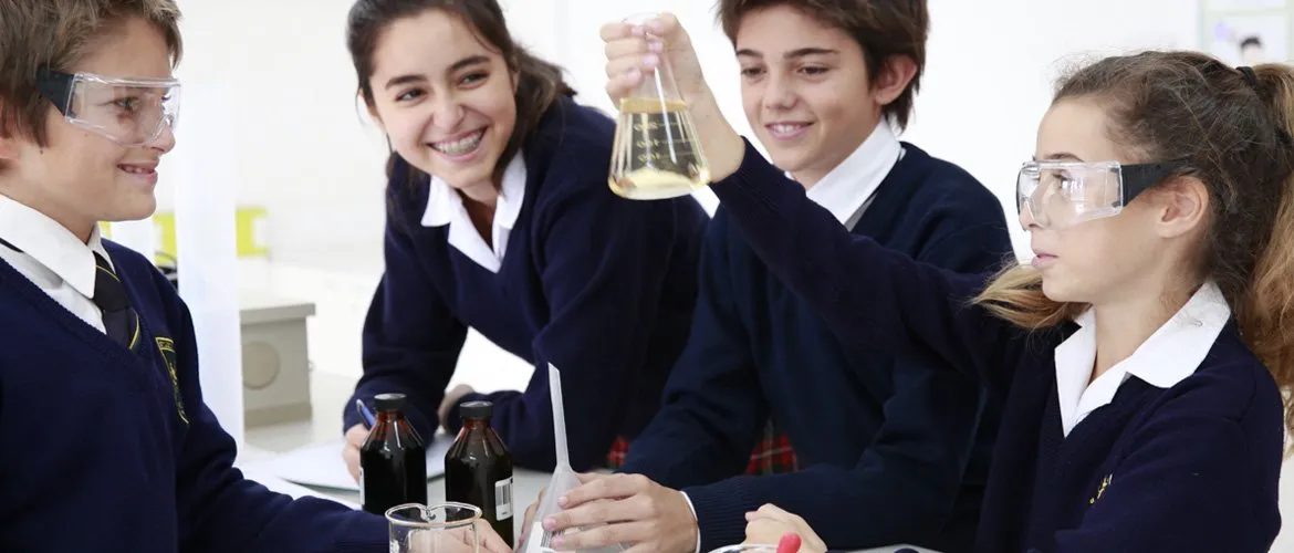 Alumnos de Secundaria con antiparras hacen un experimento en el laboratorio